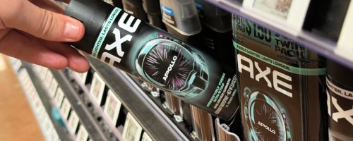 hand tipping an axe body spray off a store shelf