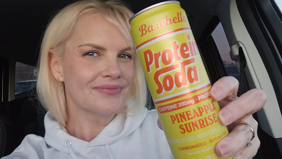 woman holding pineapple sunrise flavor barebell protein soda
