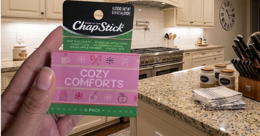hand holding a pink chapstick set in a kitchen