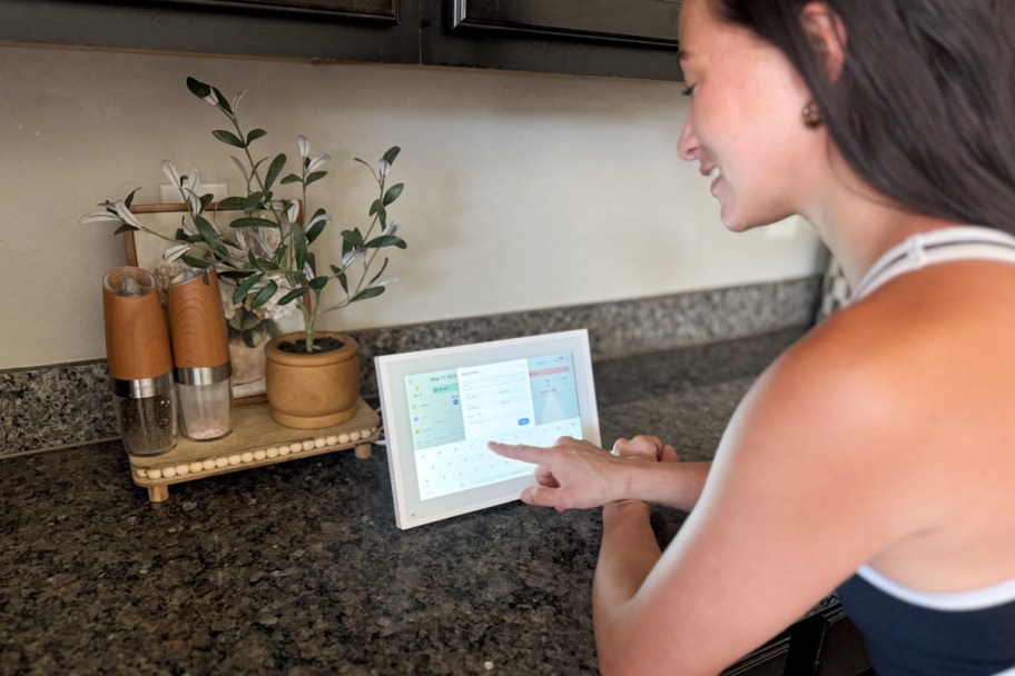 woman pressing digital calendar on counter