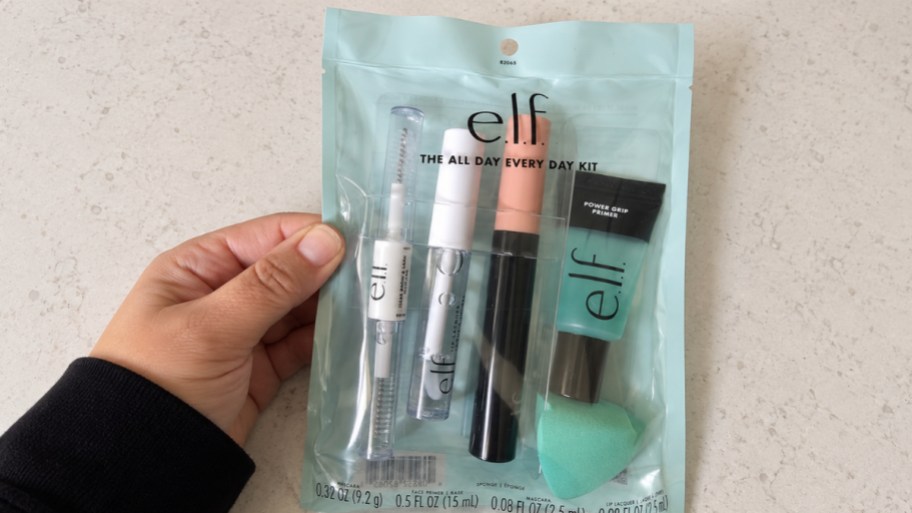 a hand holding elf all day every day face kit items