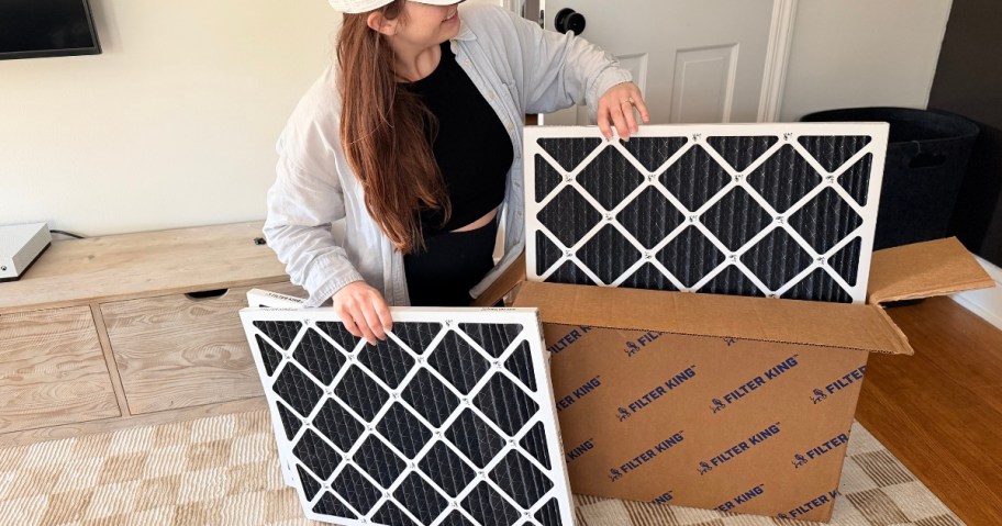 woman pulling Filter King air filters out of a box