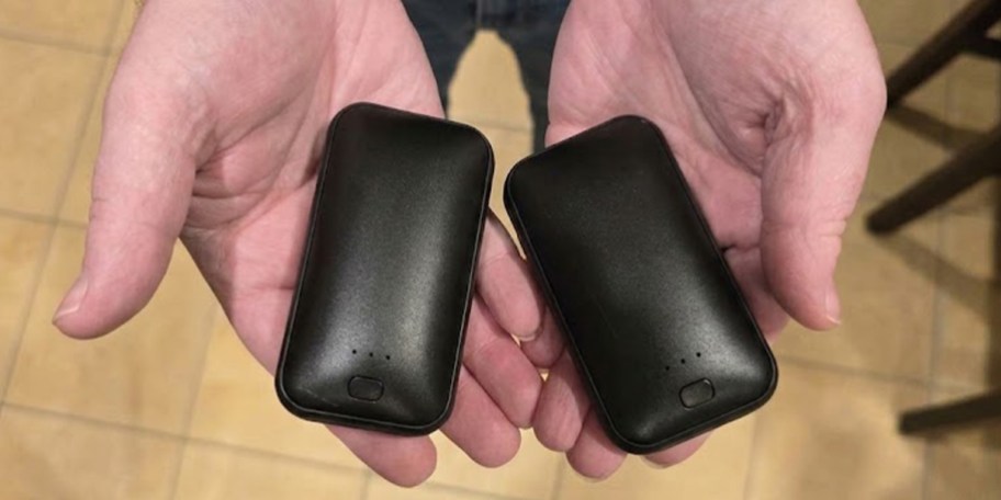 hands holding black hand warmers