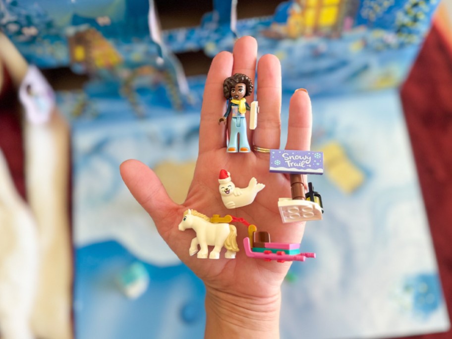 hand holding lego minifig and animals
