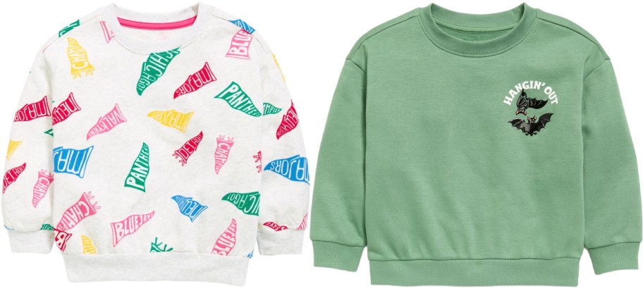Two Old Navy toddler sweatshirts, featuring an off-white sweatshirt with an all-over colorful pennant flag print on the left and a sage green sweatshirt with a Halloween bat graphic and "Hangin' Out" text on the right.