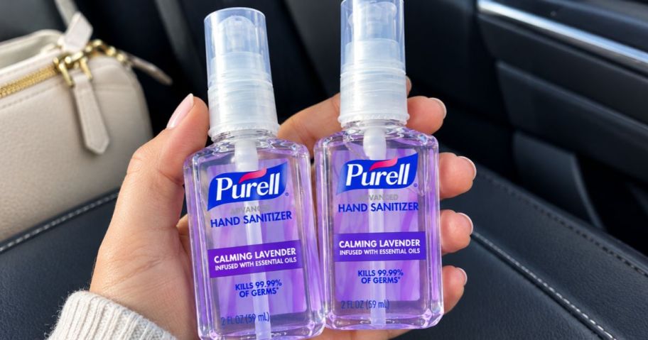 hand holding 2 bottles of lavender purell hand sanitizer