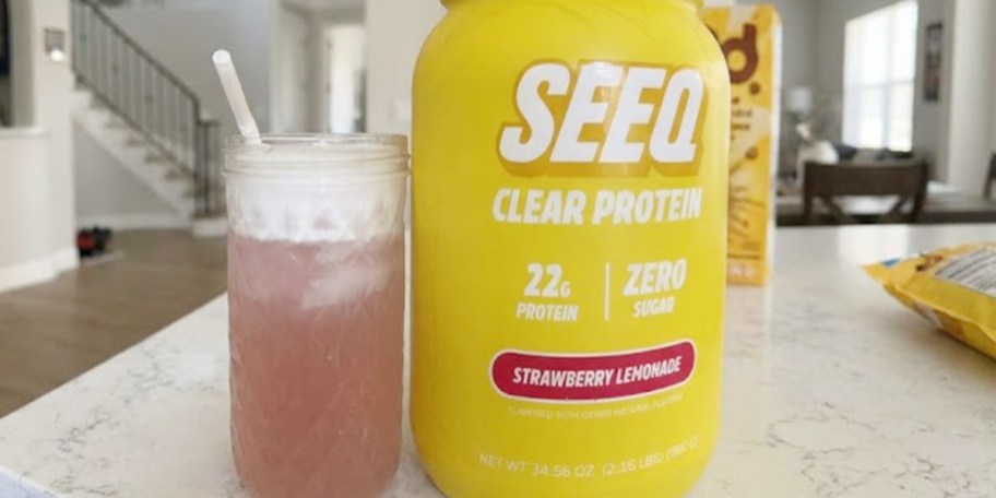 seeq clear protein powder container with drink next to it on table