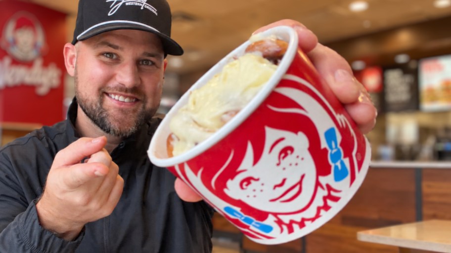 a man offering a cup of cinnabon bites in a wendys