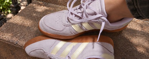 woman on steps wearing lavender adidas sneakers